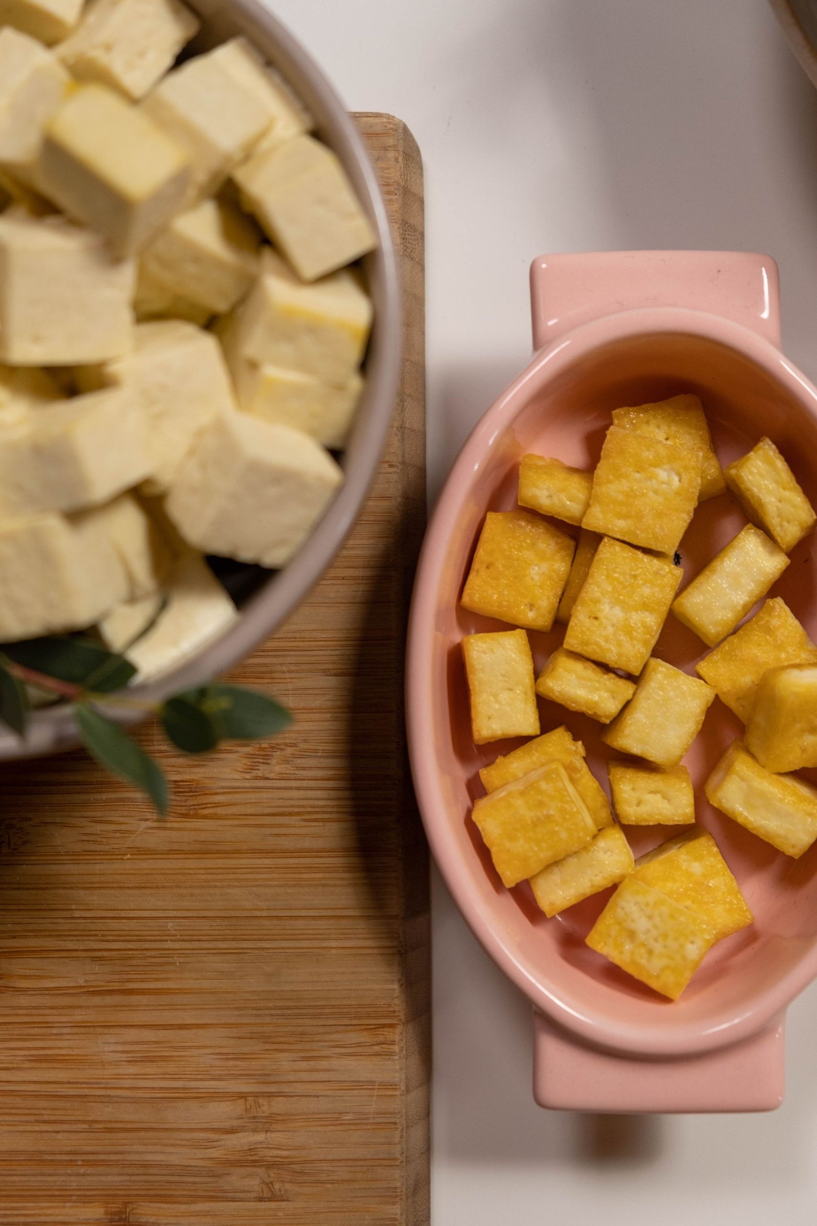 Fresh and crispy fried tofu cubes in ceramic bowls, viewed from above.